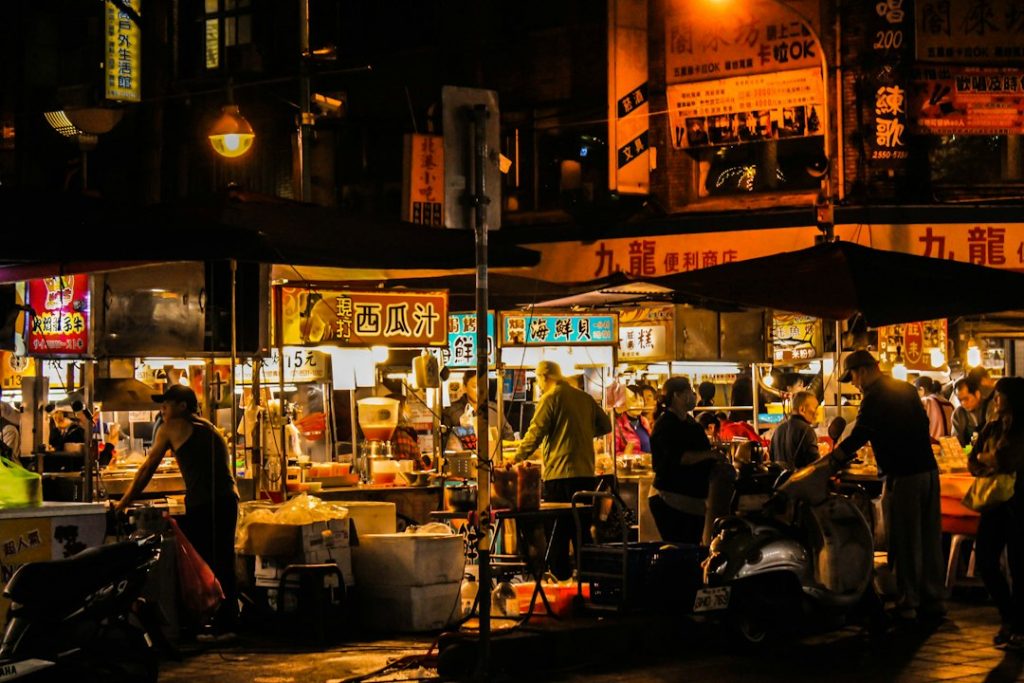 Suasana pasar kuliner malam dengan gerai makanan dan pengunjung