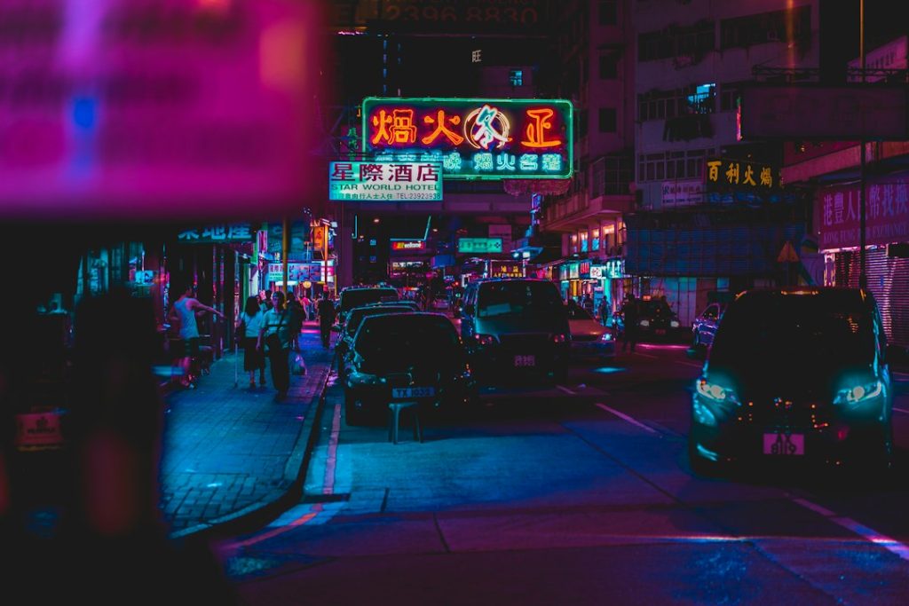 Suasana jalan kota dengan lampu neon pada malam hari